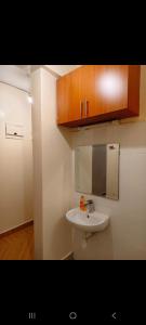 a bathroom with a white sink and wooden cabinets at Shekhy Homes in Machakos