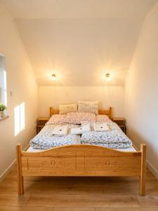 a bedroom with a wooden bed in a room at Domek z balią Pod Dębem in Zabrzeź