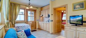 a living room with a blue couch and a television at Chalet Betty in Livigno