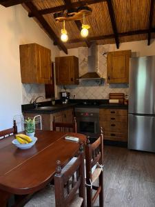 a kitchen with a wooden table and a stainless steel refrigerator at Casa Aljubet in Onil +4 photos