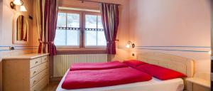 a bedroom with a bed with red sheets and a window at Chalet Betty in Livigno