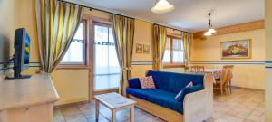 a living room with a blue couch and a table at Chalet Betty in Livigno