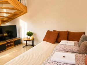 a living room with a couch and a television at Domek z balią Pod Dębem in Zabrzeź