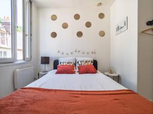 a bedroom with a large bed with red pillows at Les Fontaines in Bernay