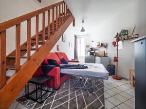 a living room with a red couch and stairs at Les Fontaines in Bernay