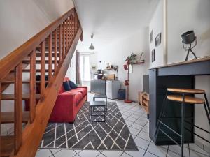 a living room with a red couch and a staircase at Les Fontaines in Bernay