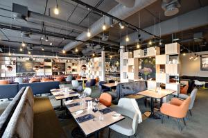 a restaurant with tables and couches and chairs at Scandic Hvidovre in Hvidovre