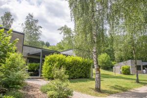 a house in a garden with a tree at chalet 1 - les jolis chalets in Barbey-Séroux