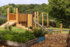 a wooden playground with a slide and a picnic table at Scandic Hvidovre in Hvidovre