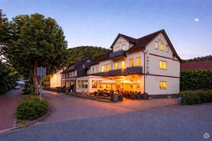 a large white building with yellow lights on it at Hotel am Kurpark in Bad Lauterberg