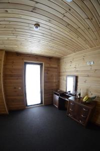a room with wooden walls and a window in a room at Curtea Boierului Hotel in Peresecina
