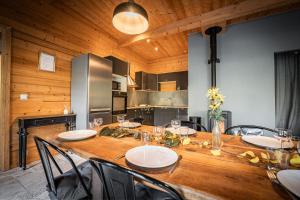 a dining room with a wooden table with chairs at chalets 4 - les jolis chalets in Barbey-Séroux
