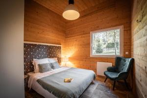 a bedroom with a bed and a chair and a window at chalets 4 - les jolis chalets in Barbey-Séroux +52 photos