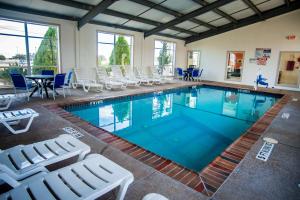 a swimming pool with chairs and a table at Motel 6-Corsicana, TX in Corsicana