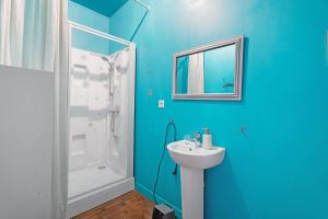 a blue bathroom with a sink and a shower at Maison le 28 in Jugon Les Lacs +31 photos