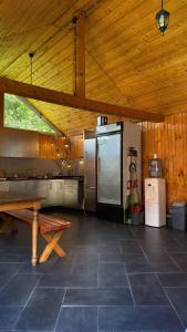 a large kitchen with a table and a refrigerator at Marginimea Sibiului - Pensiunea Darian & David in Orlat