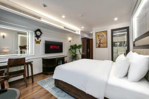 a bedroom with a bed and a desk and a tv at A25 Premium Hotel - 16 Miếu Đầm in Hanoi +30 photos