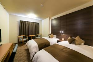 a hotel room with two beds and a table at Hotel Miyahira  in Ishigaki Island
