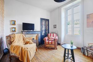 a living room with a chair and a fireplace at Maison le 28 in Jugon Les Lacs