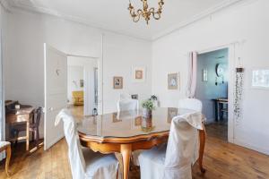 a dining room with a table and white chairs at Maison le 28 in Jugon Les Lacs