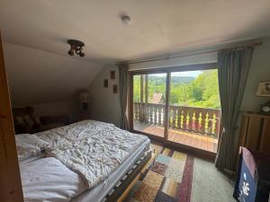 a bedroom with a bed and a large window at Ferienwohnung Sankt Hubertus in Bad Berneck im Fichtelgebirge