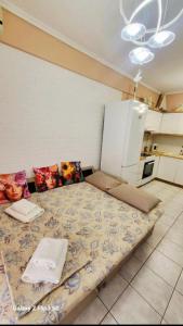 a large bed in a room with a kitchen at Apartman Malvina in Flogita