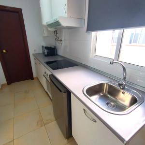 a small kitchen with a sink and a counter at Apartamentos ATARAZANAS in Málaga +2 photos