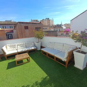 a patio with two couches and a table on a roof at Apartamentos ATARAZANAS in Málaga