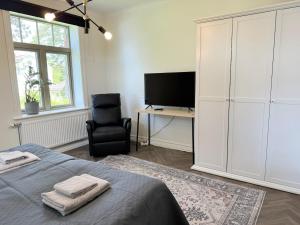 a bedroom with a bed and a chair and a television at Stava Mosters in Mariehamn