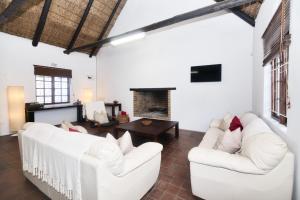 a living room with two white couches and a fireplace at The Barn Main House in Arniston