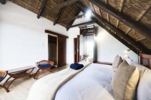 a bedroom with a large bed and a table at The Barn Main House in Arniston +37 photos