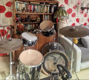 a drum set sitting in front of a book shelf at Bungu Bangu in Ventspils