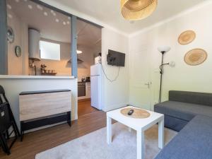 a living room with a couch a table and a refrigerator at La Chaussee in Bernay