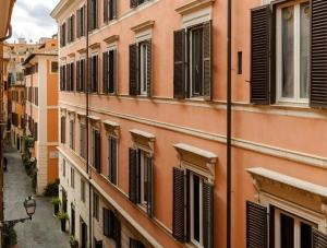 an alley of an old building with shuttered windows at Numa Rome Condotti in Rome