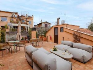a patio with a couch and tables and chairs at Numa Rome Condotti in Rome +45 photos