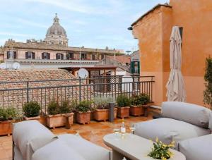 a balcony with chairs and a table and a building at Numa Rome Condotti in Rome