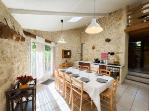 a dining room with a white table and chairs at Les instants du lot in Trespoux-Rassiels