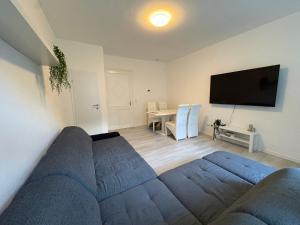 a living room with a blue couch and a tv at Modern Apartment Melk - Altstadt & Parkplatz in Melk