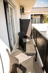 a balcony with chairs and tables on a building at Pansioni Centar in Mostar