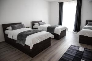 a bedroom with two beds and a large window at Pansioni Centar in Mostar