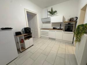 a kitchen with white cabinets and a tile floor at Modern Apartment Melk - Altstadt & Parkplatz in Melk