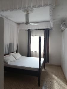 a bed in a room with a window at Peaceful Diani apartment in Diani Beach