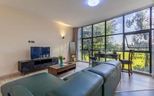 a living room with a blue couch and a tv at Kika Des Hotel Suites - Serviced Apartments, Westland, Nairobi in Nairobi