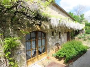 a stone building with a window and some plants at Gite Chez Santou in Rocamadour