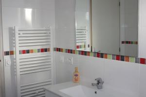 a white bathroom with a sink and a mirror at Gite Chez Santou in Rocamadour