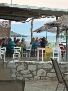 a group of people sitting at a table near the ocean at Camping Dias in Gythio +22 photos