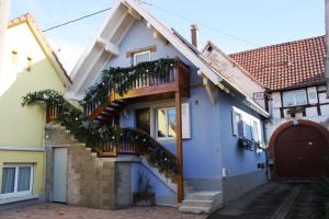 a blue house with a balcony and a door at Gites des Dix Vins in Dangolsheim