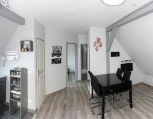a dining room with a table and a black chair at Gites des Dix Vins in Dangolsheim +11 photos