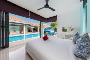a bedroom with a large bed and a swimming pool at 4BR Luxury Pool Retreat - Villa Azura Nai Harn in Nai Harn Beach +35 photos