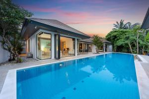 a swimming pool in front of a house at 4BR Luxury Pool Retreat - Villa Azura Nai Harn in Nai Harn Beach
